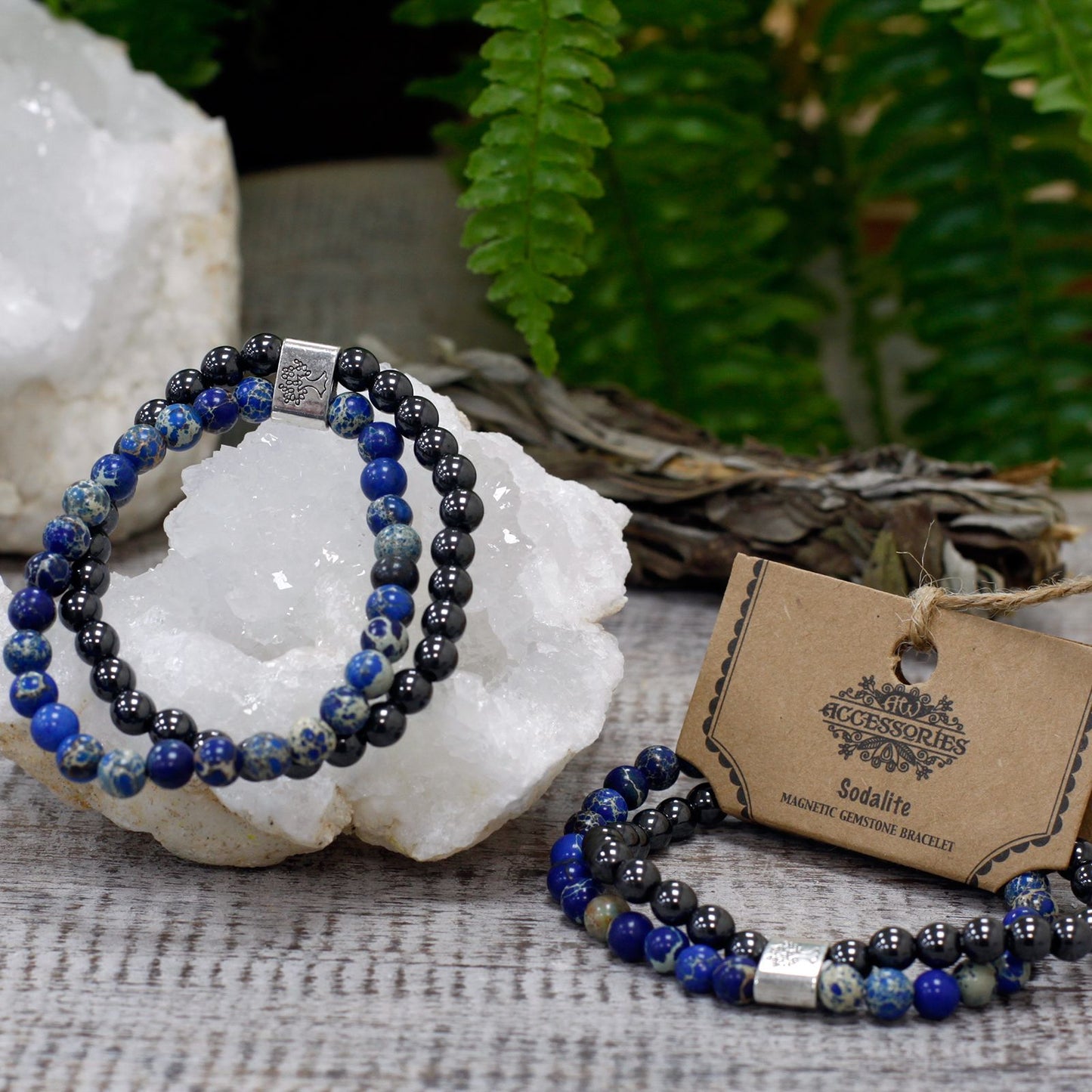 Two beaded bracelets on a white stone surface with a tag and natural elements in the background