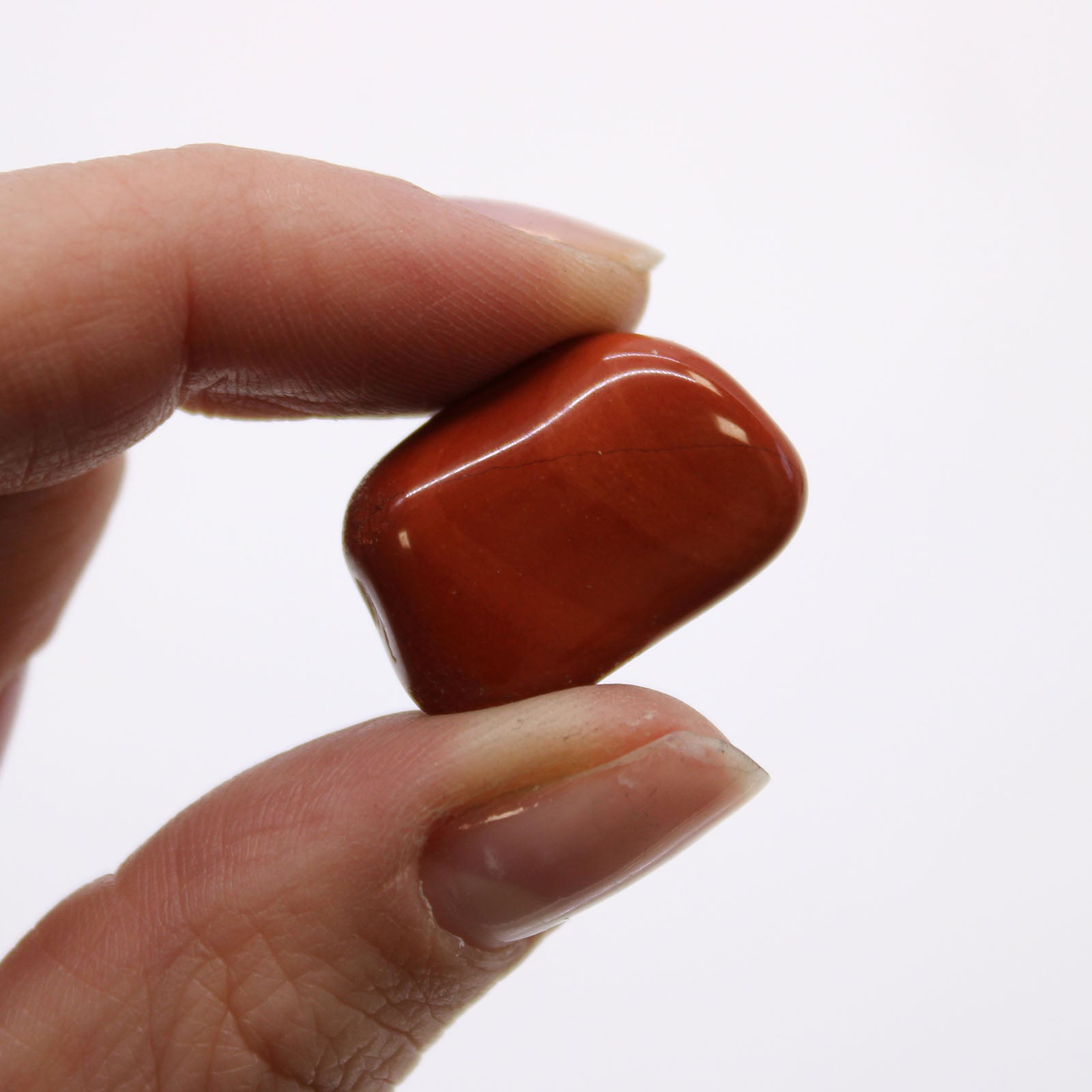 Close-up of Red Jasper tumbled stones showing unique shapes and rich red colors, perfect for meditation and chakra balancing.