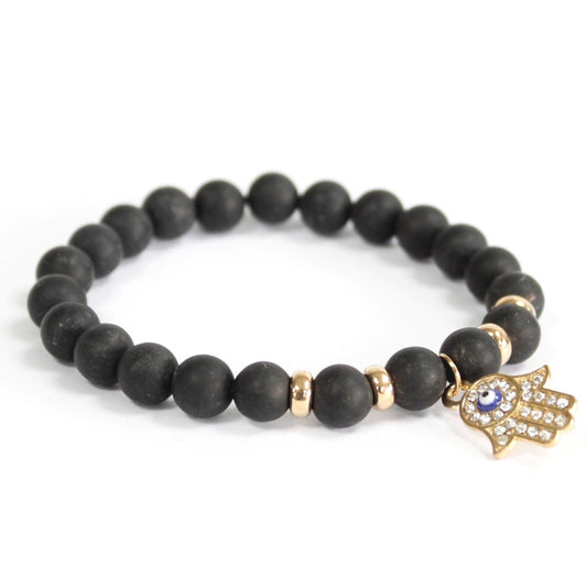 Black beaded bracelet with a gold and blue evil eye charm on a white background