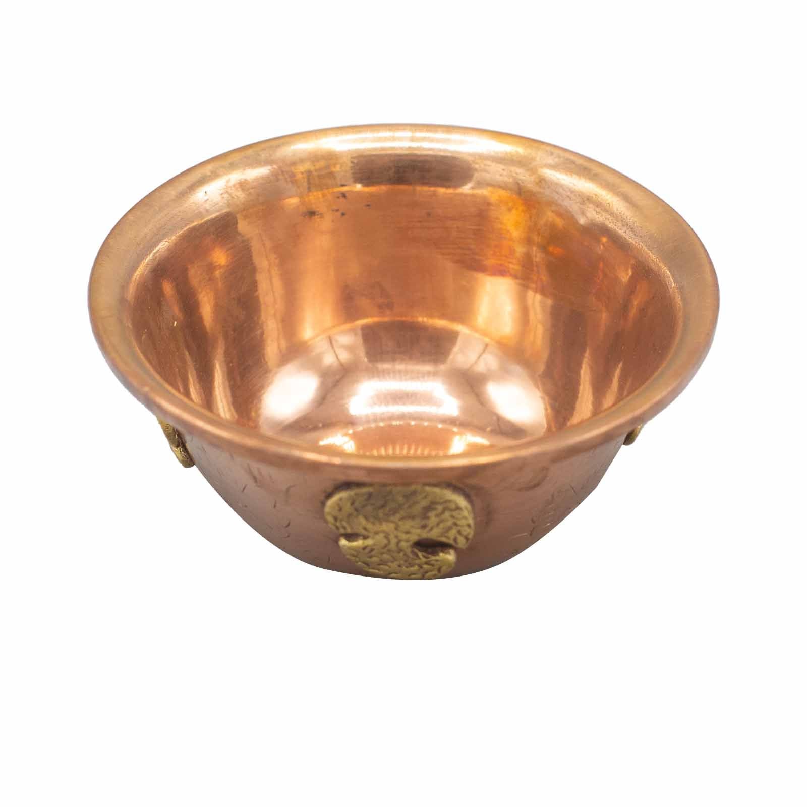 Copper bowl with a decorative emblem on a white background