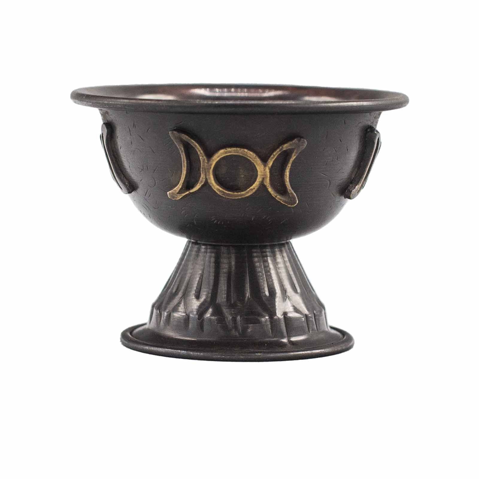 Black ceramic bowl with gold moon phase design on a white background